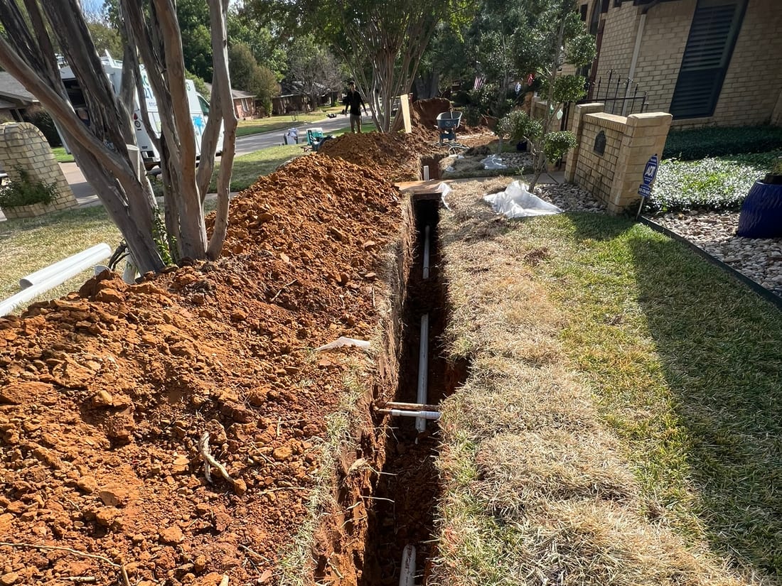 A completed sewer line trench across a DFW yard by Encore Plumbing